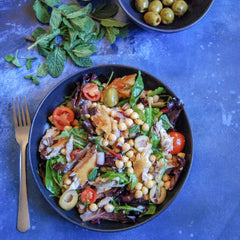 Nuri Mackerel Spiced in Olive Oil ingredients display olives, cucumber, and spices.