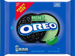 Dunk-ready OREO Mint Creme cookies with a glass of milk.
