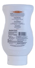 Peach Real syrup bottle in a glass, vibrant color enhances mocktails and iced beverages.