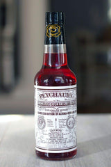 PEYCHAUD'S bottle label close-up aiding authentic aperitif recognition.