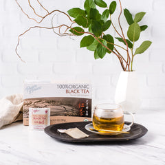 Pouring Prince of Peace organic black tea into a glass reveals amber color.