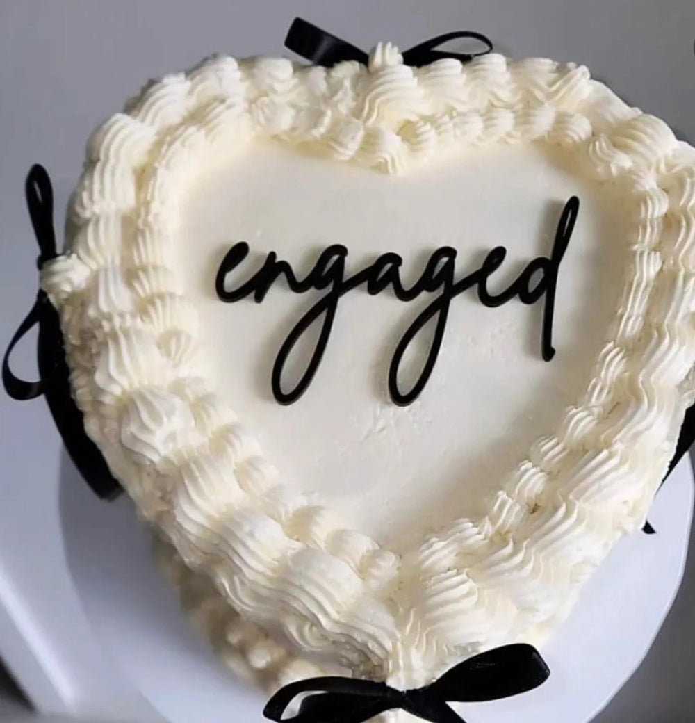 QPARTYFIRE engaged cake topper in black acrylic adds a sleek centerpiece.