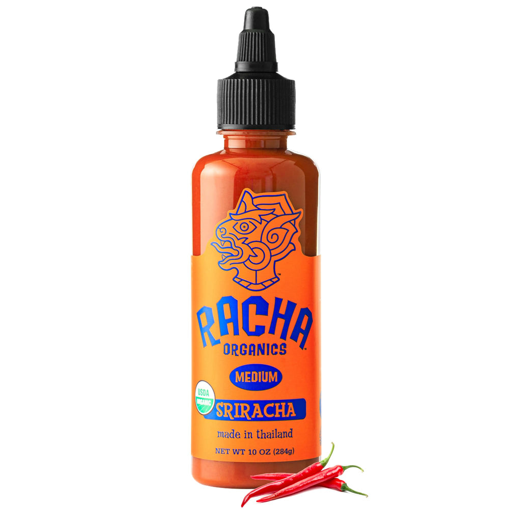 Racha Organics Orange Racha hot sauce bottle pouring for bold flavor.