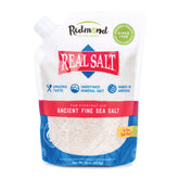 Redmond Real Salt bottle being poured for vibrant cooking flavor.