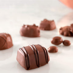Close-up of Russell Stover milk chocolate truffle with smooth center.