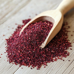 SavorSatch Ground Sumac jar on countertop with lemon and herbs for citrus lift.