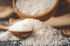 Seasonello coarse salt poured from a shaker into a pan for roasting