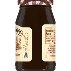 Fresh apples and cider behind Smucker's apple butter jar.