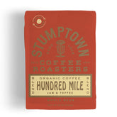 Stumptown Hundred Mile organic whole bean coffee bag front label showing jam and toffee notes, breakfast-friendly.