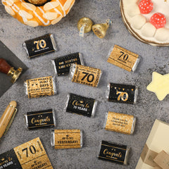 Applying Tenare 70th birthday stickers to chocolates for a polished party treat.