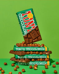 Tony's Chocolonely Milk Hazelnut Bar cracked piece highlights hazelnuts and creamy chocolate.