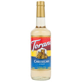 Torani Cheesecake Syrup bottle closeup highlighting creamy flavor for coffee and desserts.