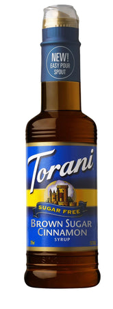 Torani sugar-free Brown Sugar Cinnamon syrup bottle beside a coffee cup, suggesting flavorful sugar-free beverages