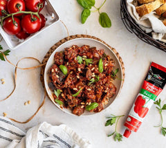 Organic Tuscanini tomato paste tube close-up showing kosher and non-GMO labels.