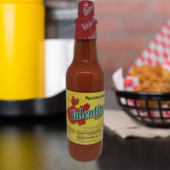 Valentina Salsa Red Hot Sauce with a dipping chip for flavor.
