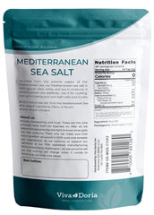 Viva Doria coarse salt crystals beside a spoon, ideal for seasoning meats and vegetables.