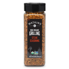 Watkins Organic Steak Seasoning bottle pour showing grill-ready flavor for steaks