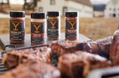 Watkins Yellowstone seasoning being sprinkled on chicken in a hot skillet