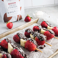 Pouring Wildly Organic cacao powder into a smoothie for antioxidant boost