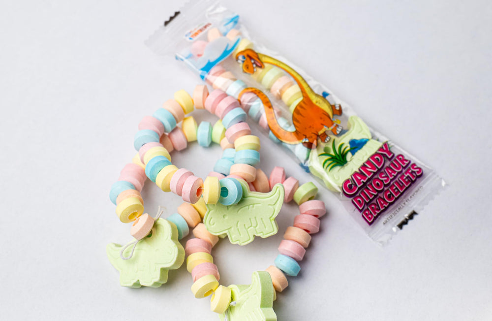 4YoreElves dino party favors shown with bracelets and pendants for festive bags.
