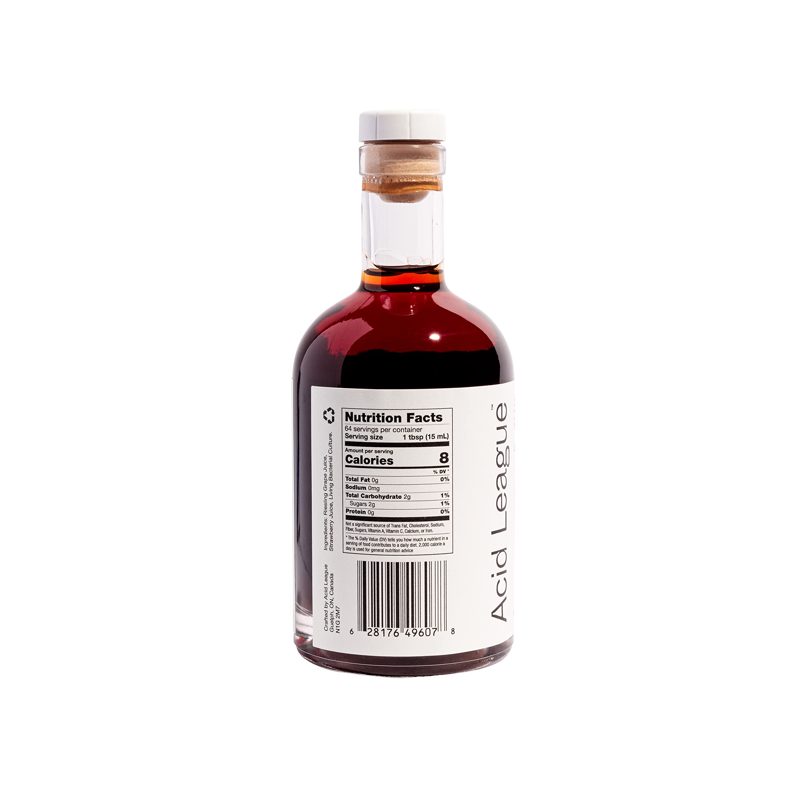 Pouring Acid League Strawberry Rosé Living Vinegar to brighten a salad.