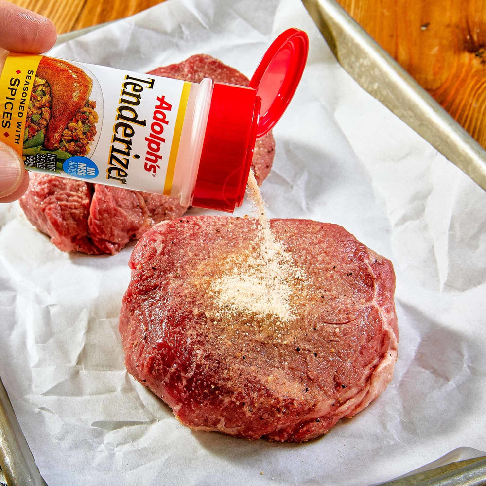 Pork chops seasoned with Adolph's Seasoned Tenderizer before grilling for aroma.