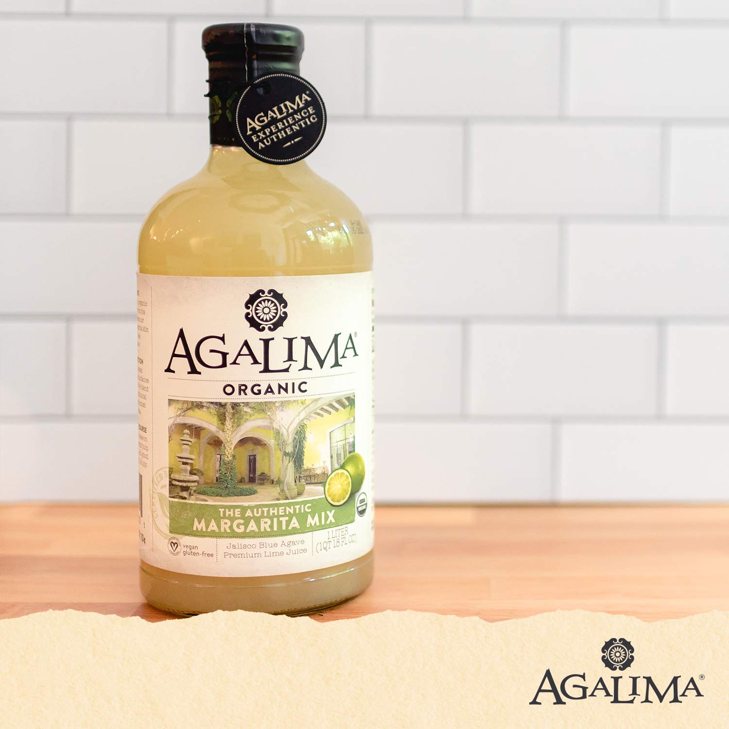 Pouring Agalima Margarita Mix over ice for bar-quality cocktails at home.