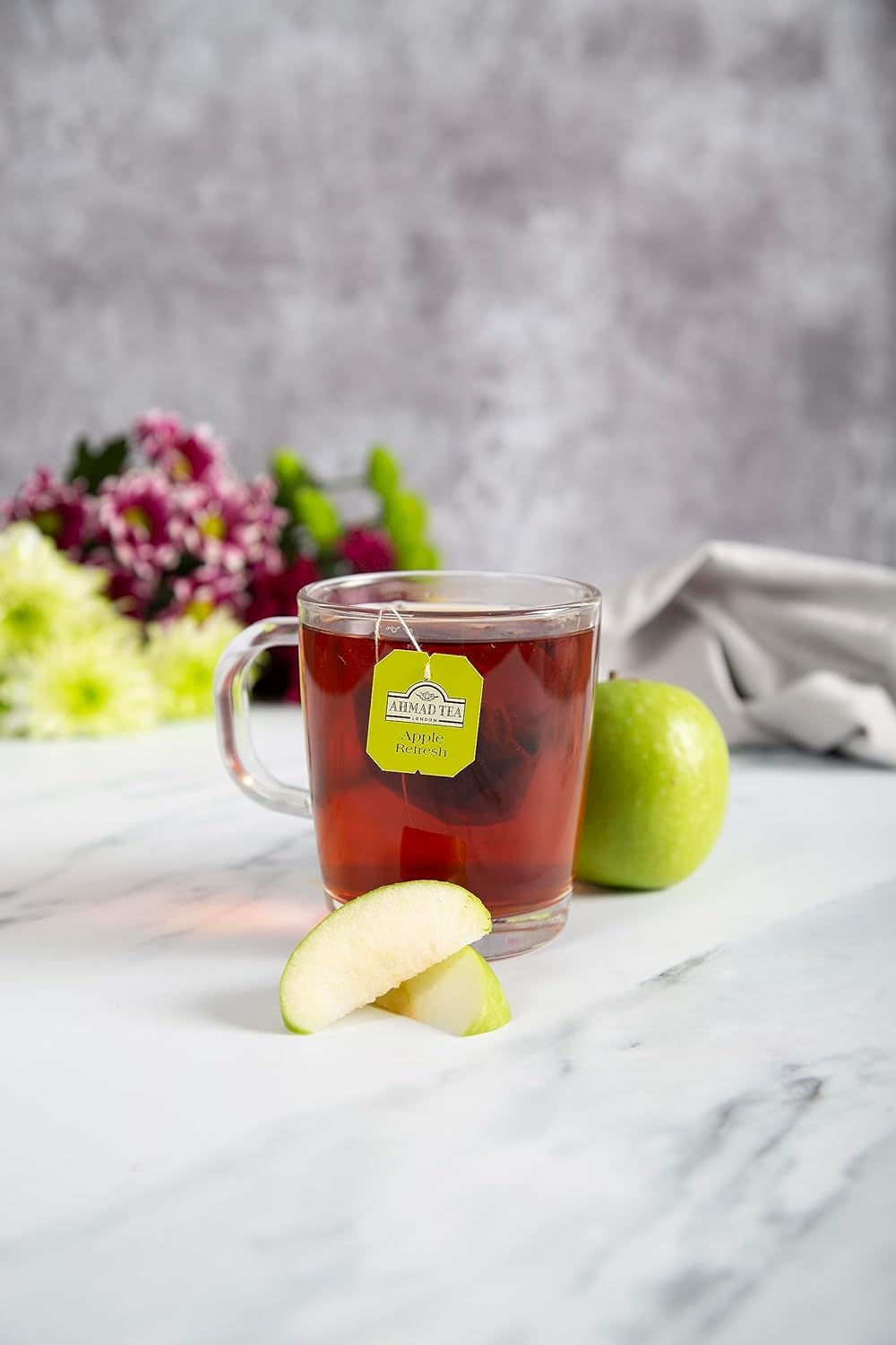 Brewed Ahmad Tea Apple Refresh cup releasing crisp apple aroma.