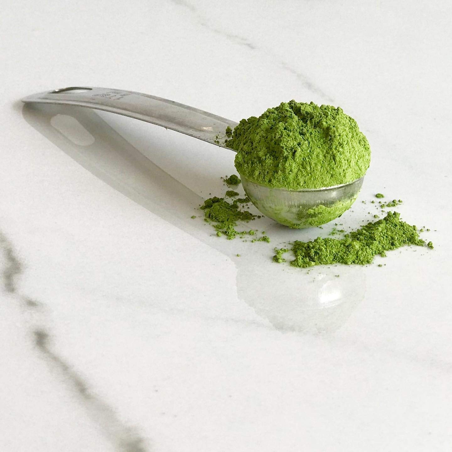 Akira Matcha powder in a latte cup with creamy foam