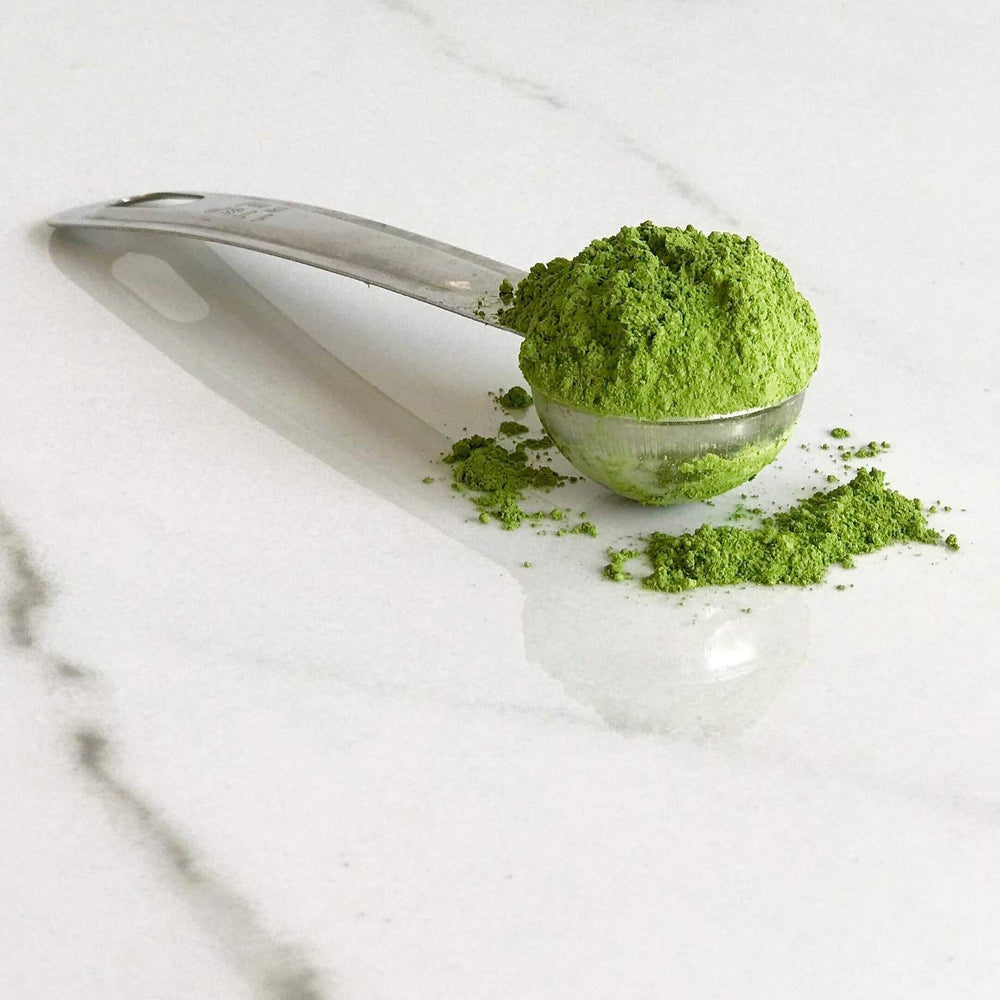 Akira Matcha powder in a latte cup with creamy foam