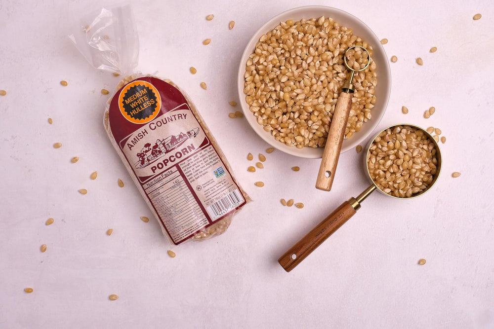 Amish Country Popcorn kernels being poured for easy portioning.