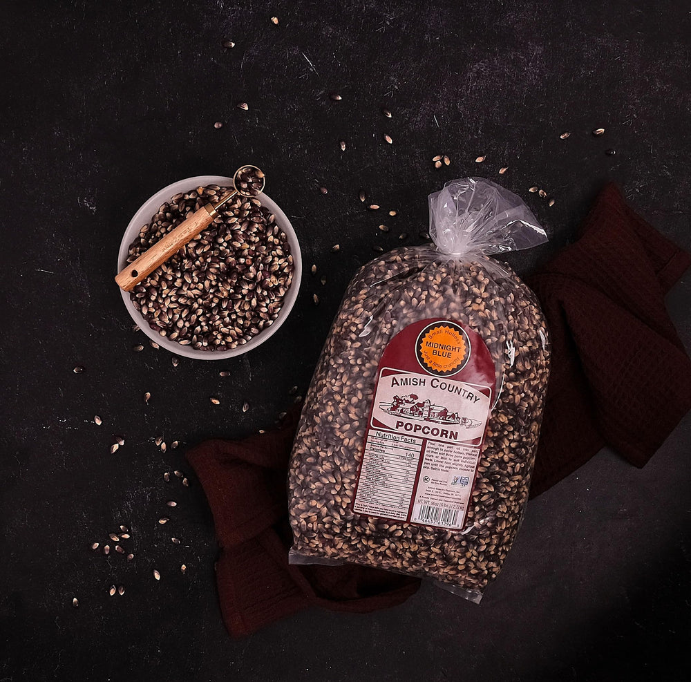 Amish Country Popcorn Midnight Blue kernels popping in a pan with aroma rising.