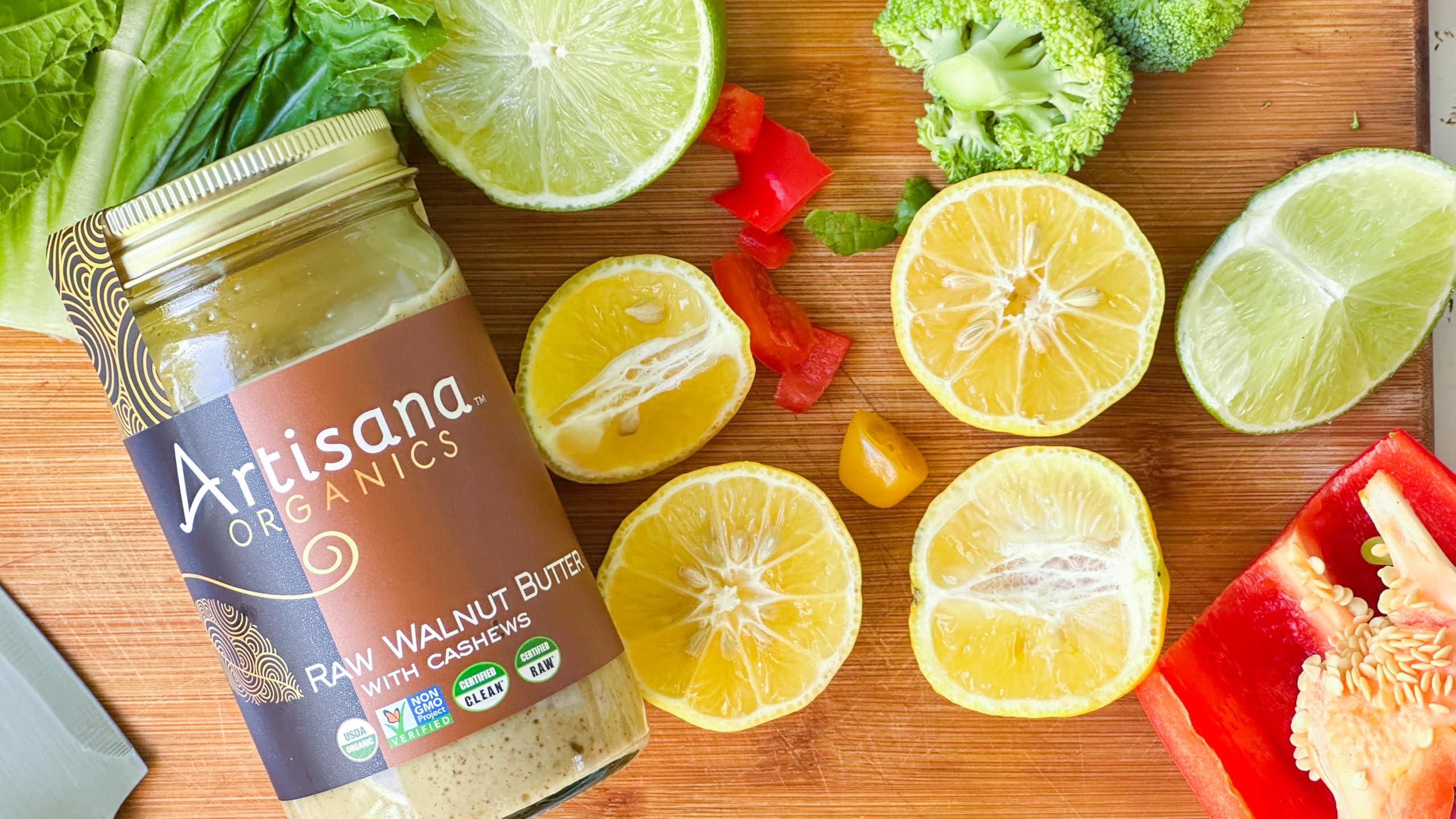 Artisana raw walnut butter with spoon reveals smooth texture.