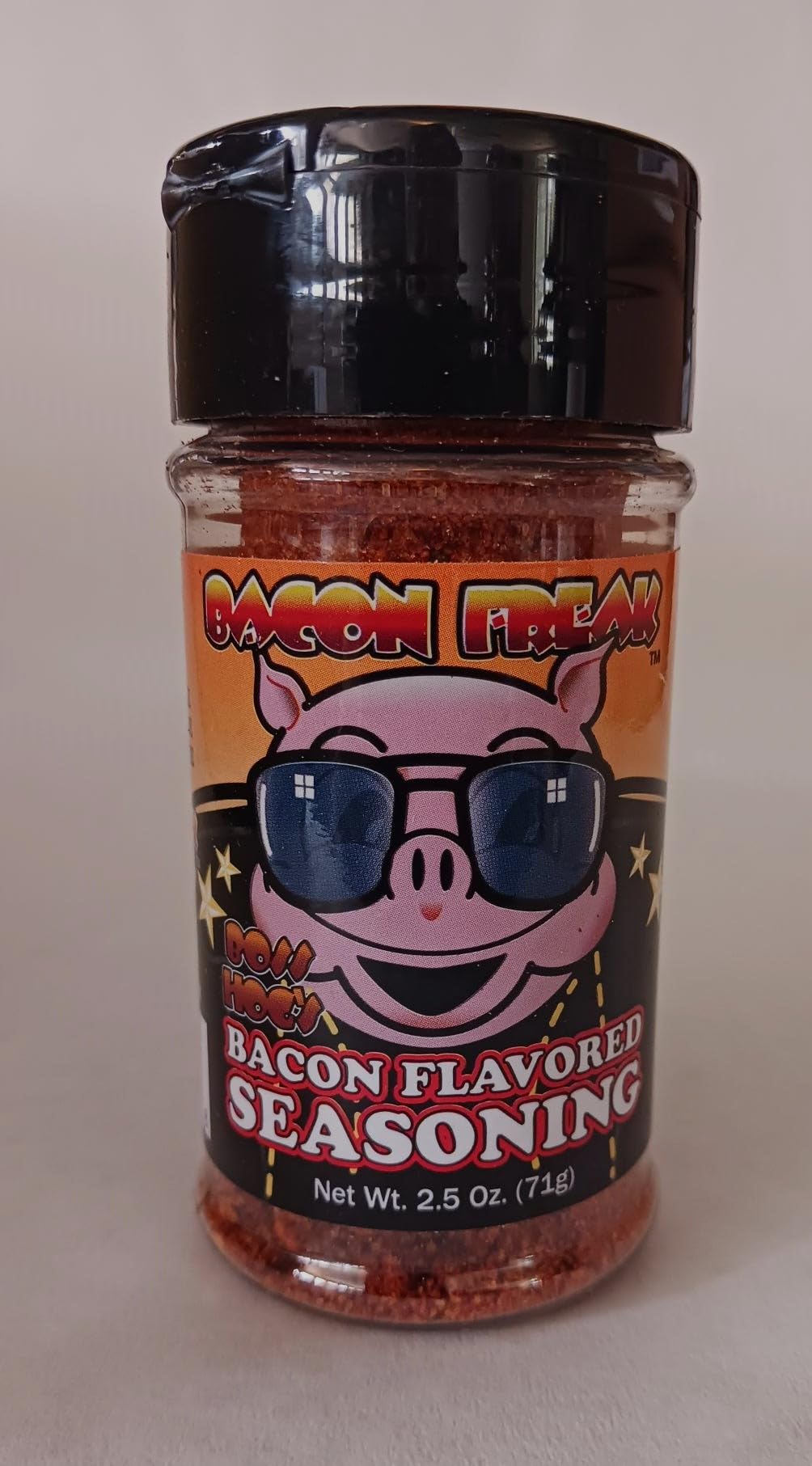 Bacon Freak Boss Hog Bacon Seasoning bottle pouring for rich, smoky flavor at home.