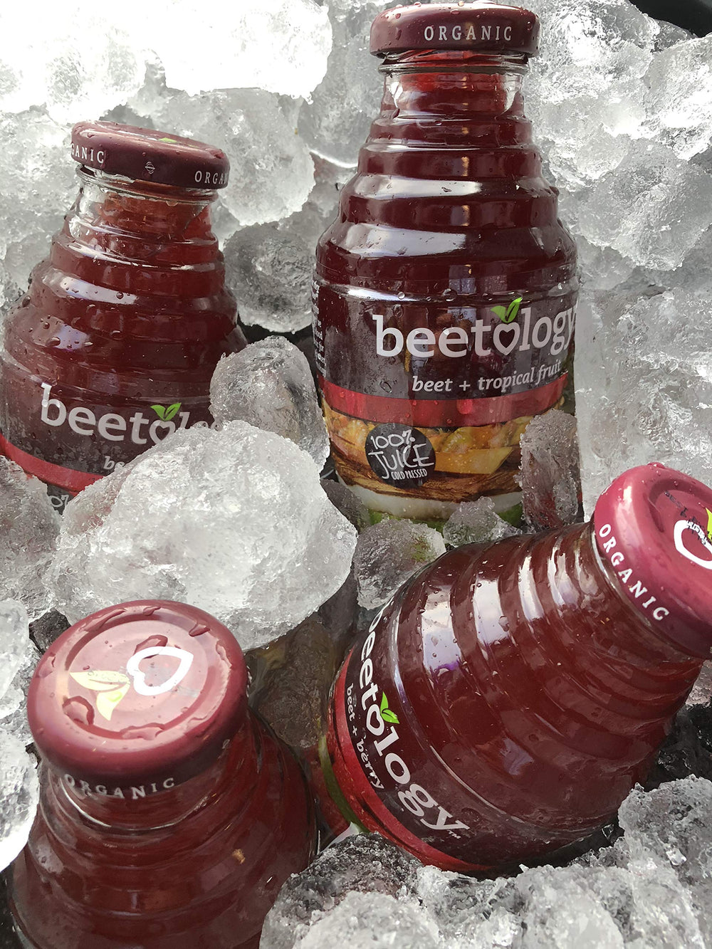 Beetology glass of juice on wood, showcasing a versatile, ready-to-drink beverage.