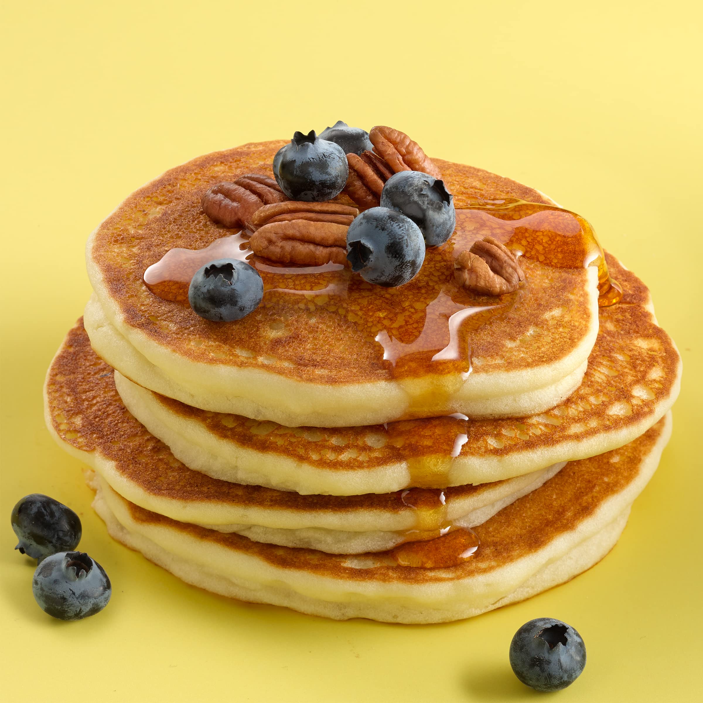 Betty Crocker Bisquick Shake 'n Pour mini pancakes cooking on a griddle.