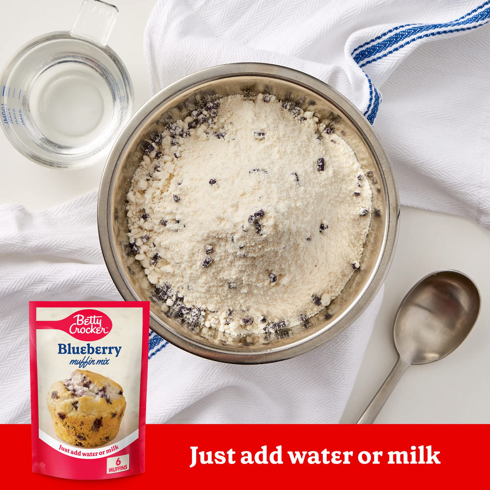 Betty Crocker Blueberry Muffin Mix batter poured into tin for golden tops.