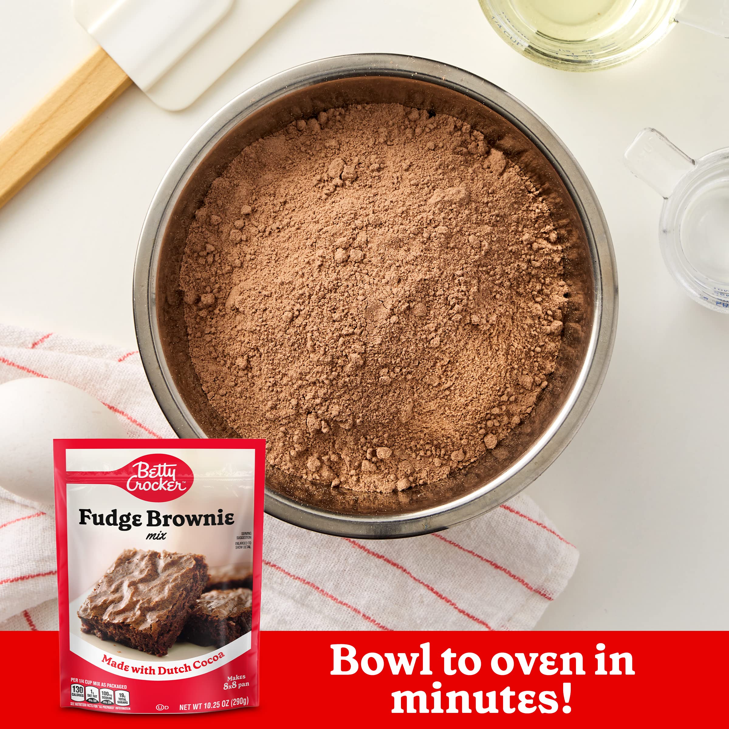 Brownie batter being stirred in a mixing bowl with Betty Crocker mix