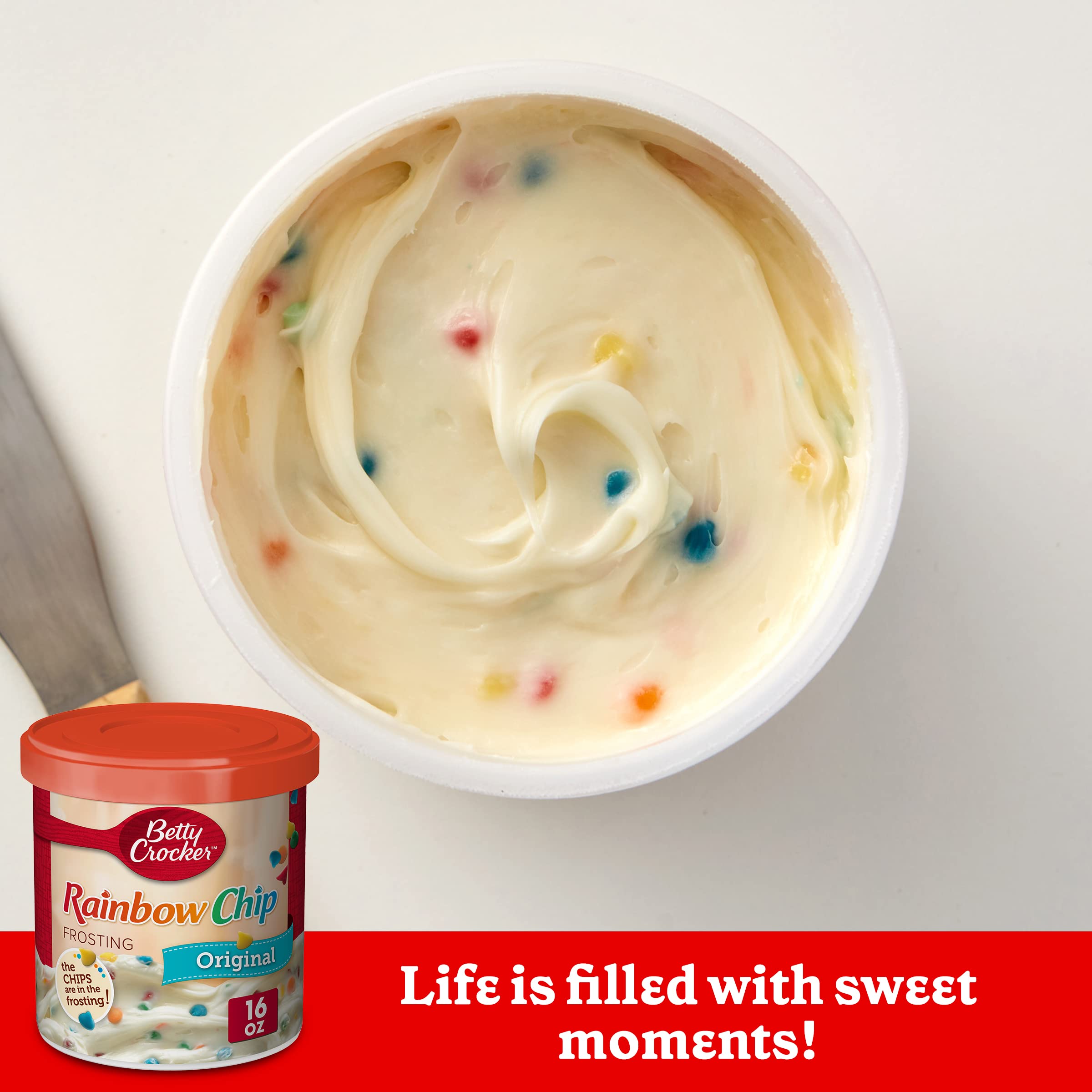 Betty Crocker Rainbow Chip Frosting being poured over a cake for vibrant celebration.