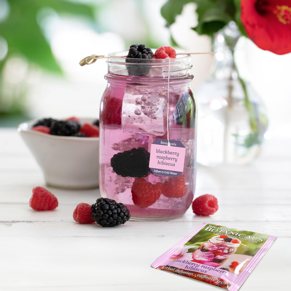 Glass of water with Bigelow Botanicals infusion tea bag for a light, fruity sip