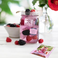 Glass of water with Bigelow Botanicals infusion tea bag for a light, fruity sip
