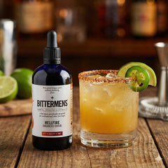 Bittermens Hellfire cocktail glass with a vibrant drink showing heat and depth.