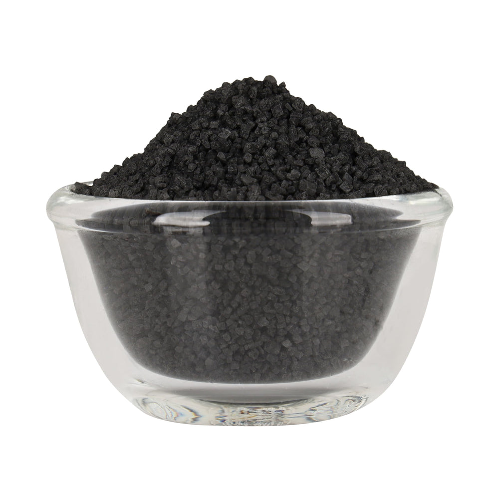 Bless International Black Salt crystal close-up in a spoon for purification rituals
