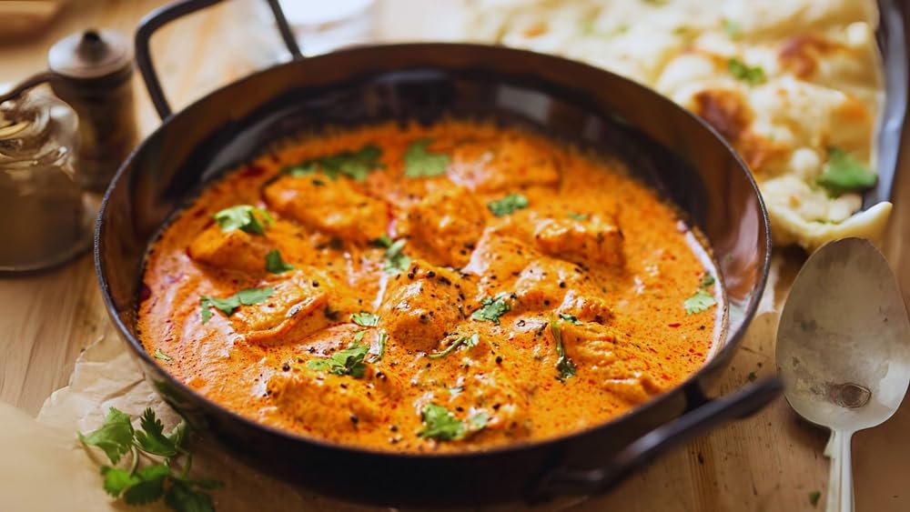 Pouring Blue Mountain Country Jamaican Curry Powder from shaker for quick flavor boost