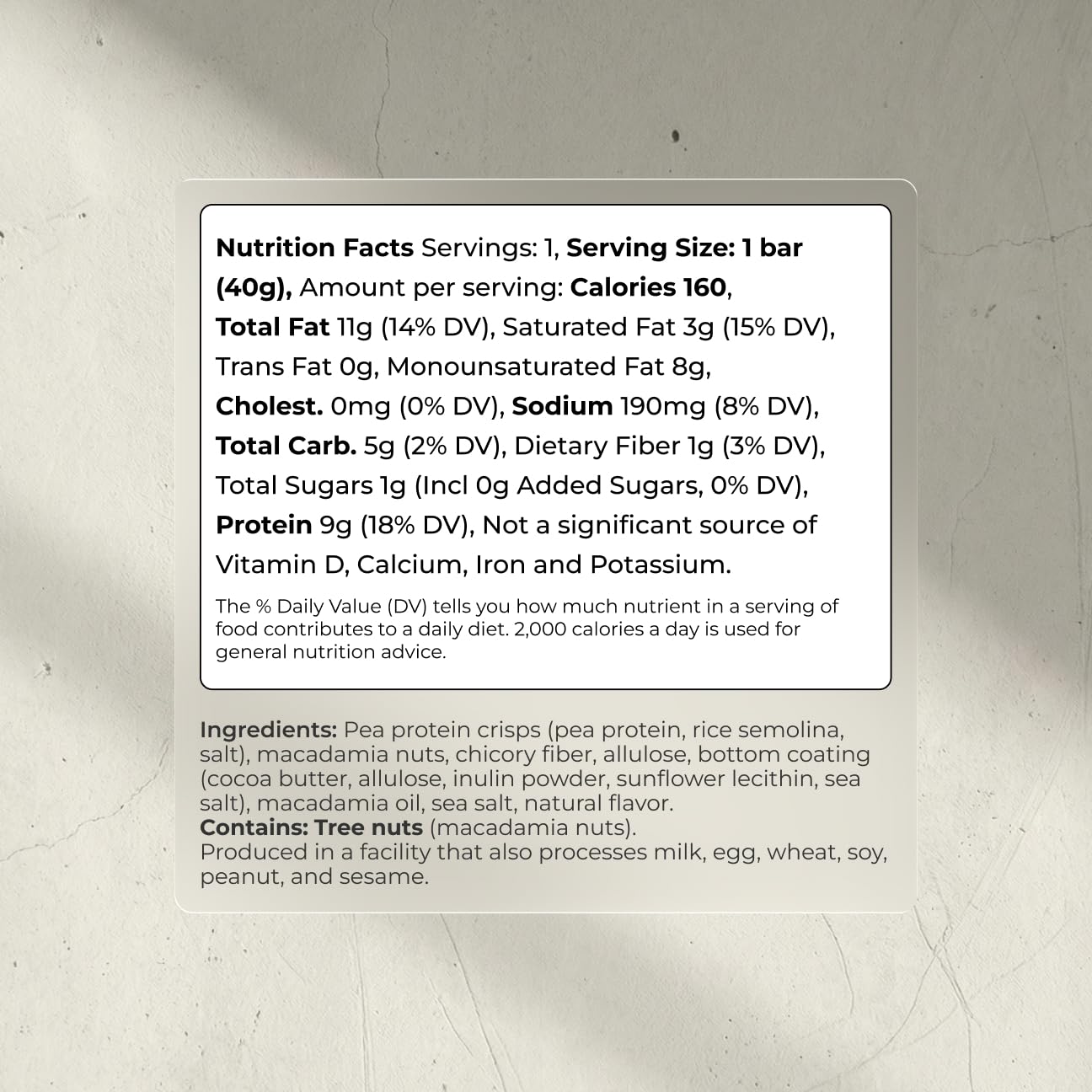 Blueprint Bryan Johnson white cocoa macadamia bar half-eaten reveals creamy texture with nuts.