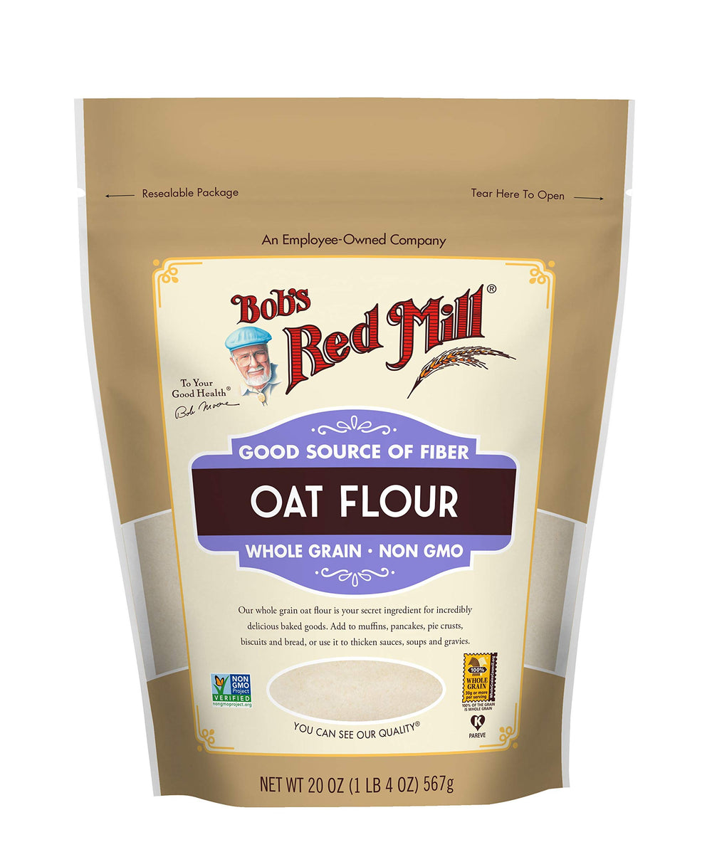 Measuring scoop pouring Bob's Red Mill oat flour into bowl