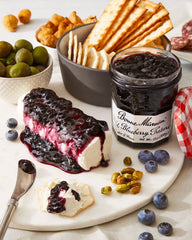 Closeup of Bonne Maman jar showing glossy blueberry preserves and fruit pieces.