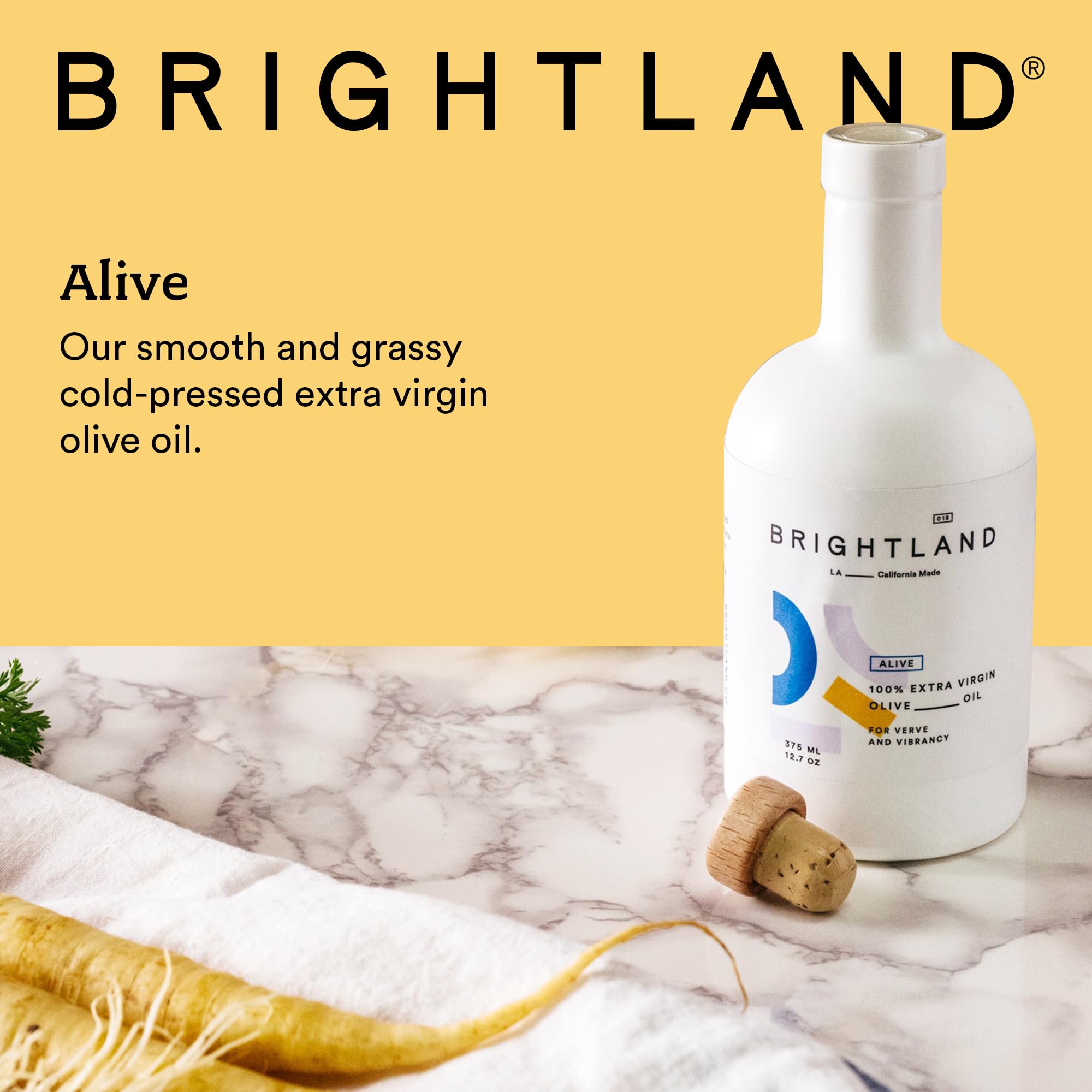 Brightland Alive olive oil being poured over greens.