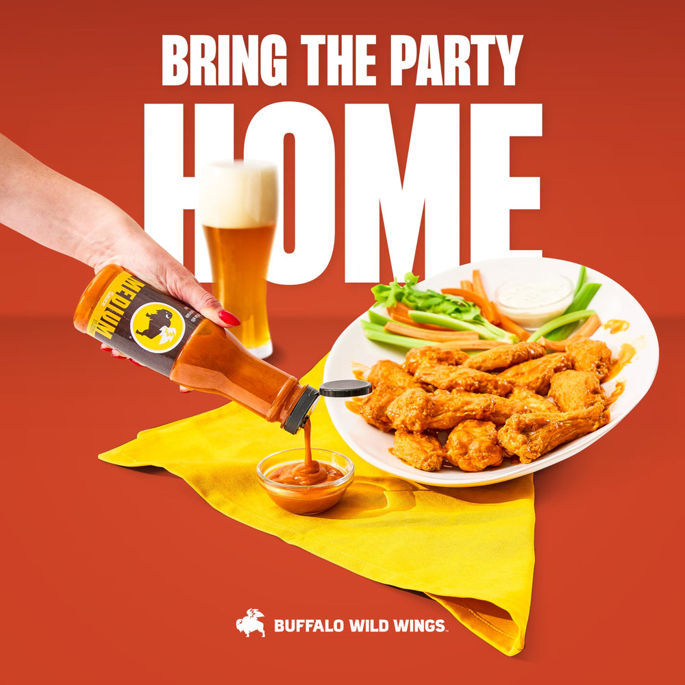 Buffalo Wild Wings Medium Buffalo Sauce bottle beside tailgate spread