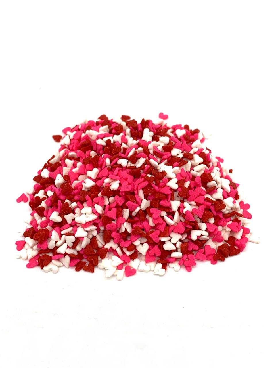 Close-up of tiny red, white, and pink heart shapes for cake decorating.